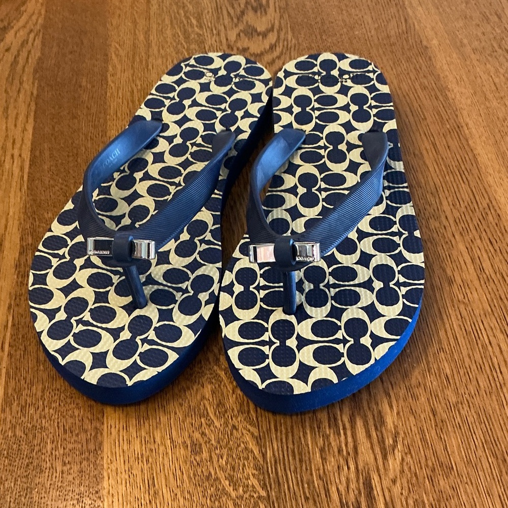 Woman’s Coach navy/tan flip flop. Size 6. Metal silver bow on front.New! So cute